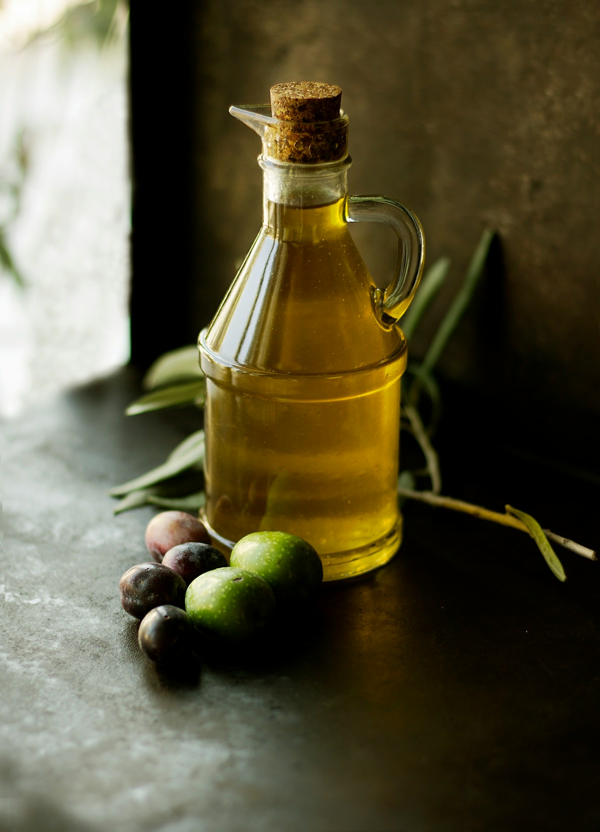 Bottiglia di olio extravergine su tavolo di legno rustico
